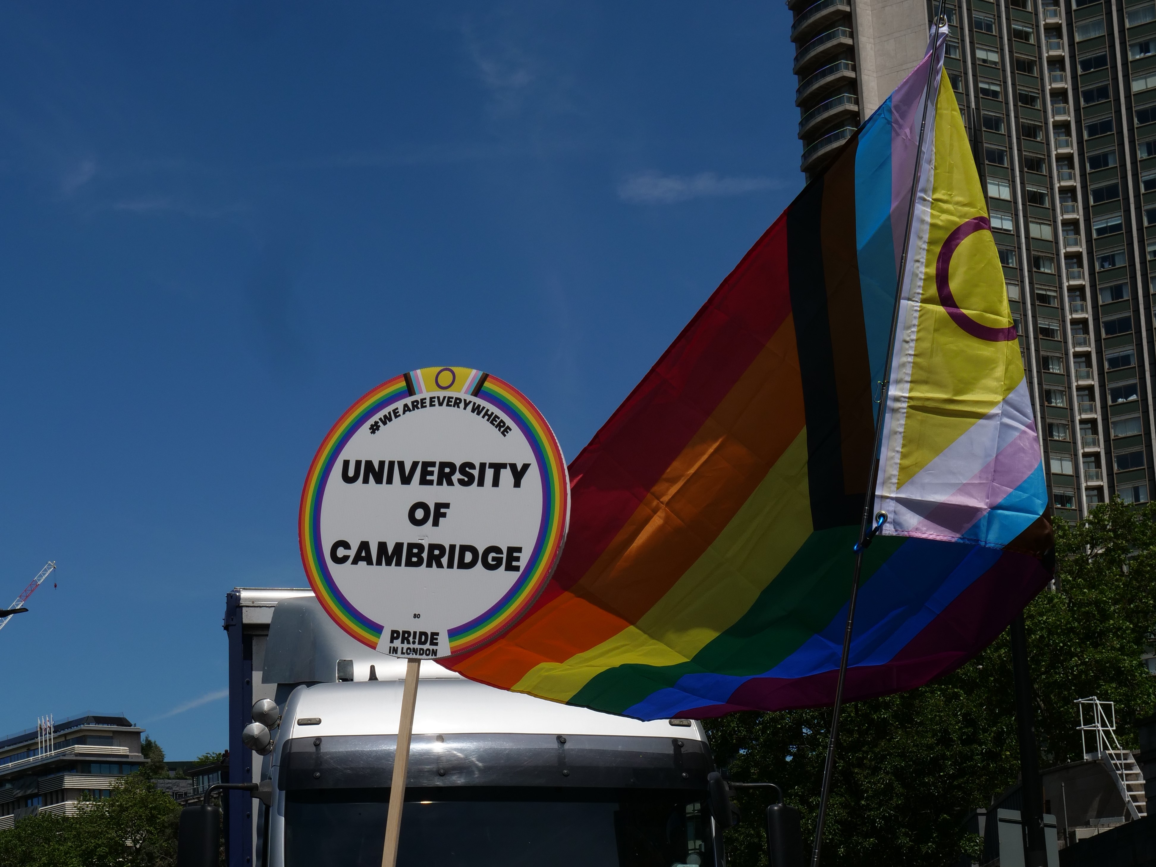 University of Cambridge placard with rainbow flag backdrop