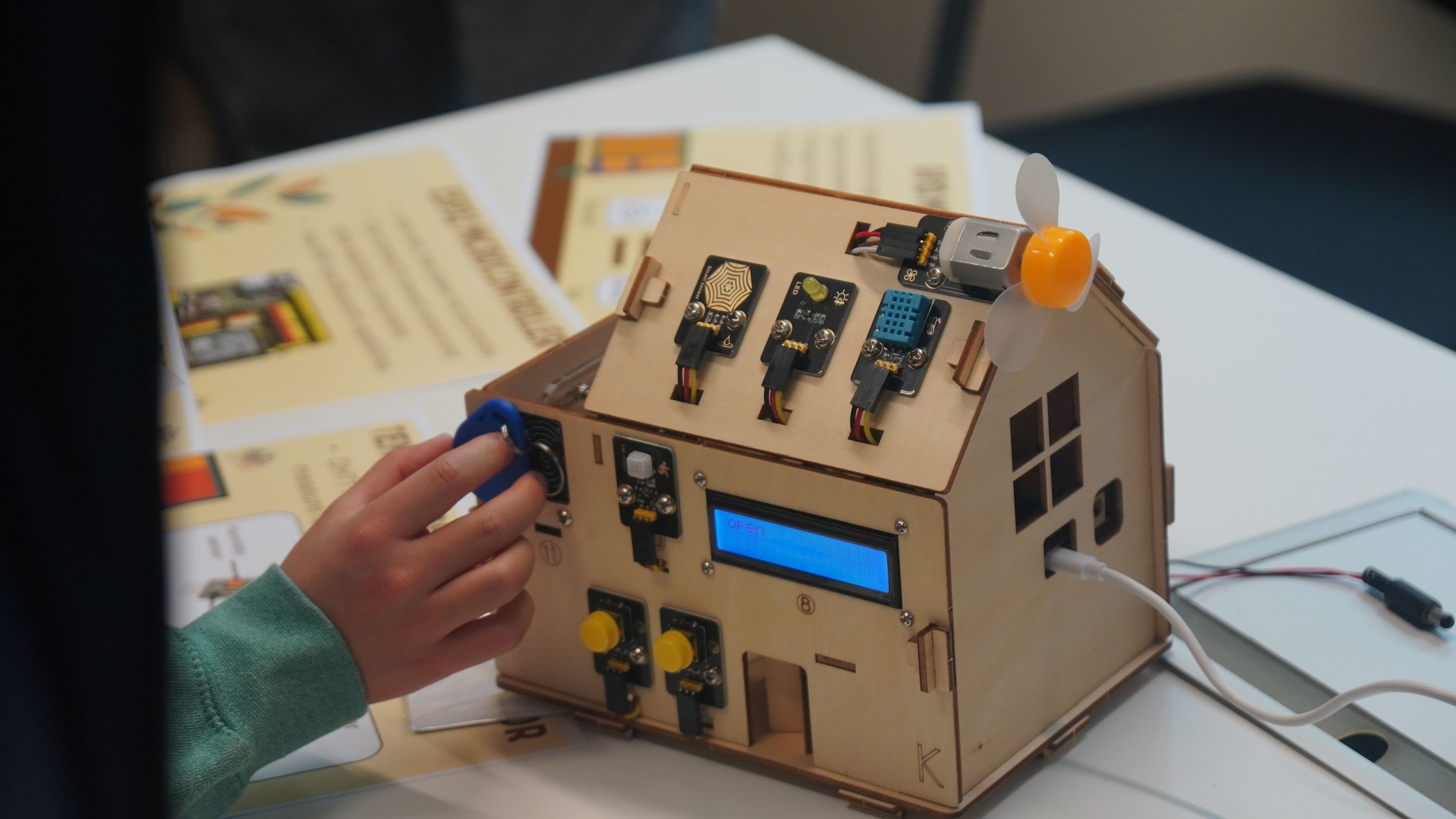 A small model wooden house covered in sensor technology.