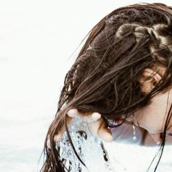 Woman washing hair in body of water