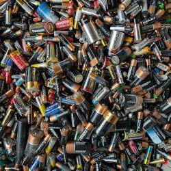 Assorted batteries in a rubbish pile.