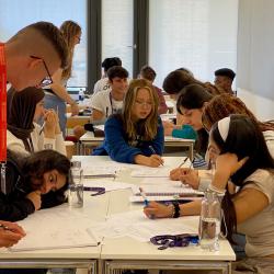 Year 12 students around a table working and smiling