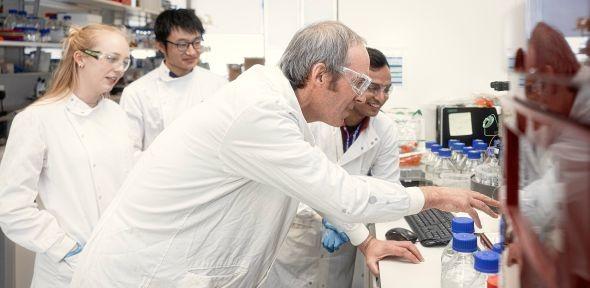 Students with professor in lab setting.