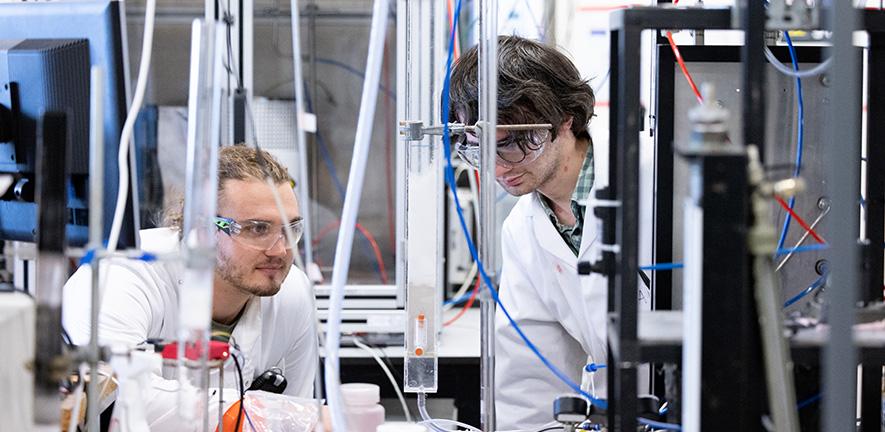 Two students working at a chemical engineering reaction rig