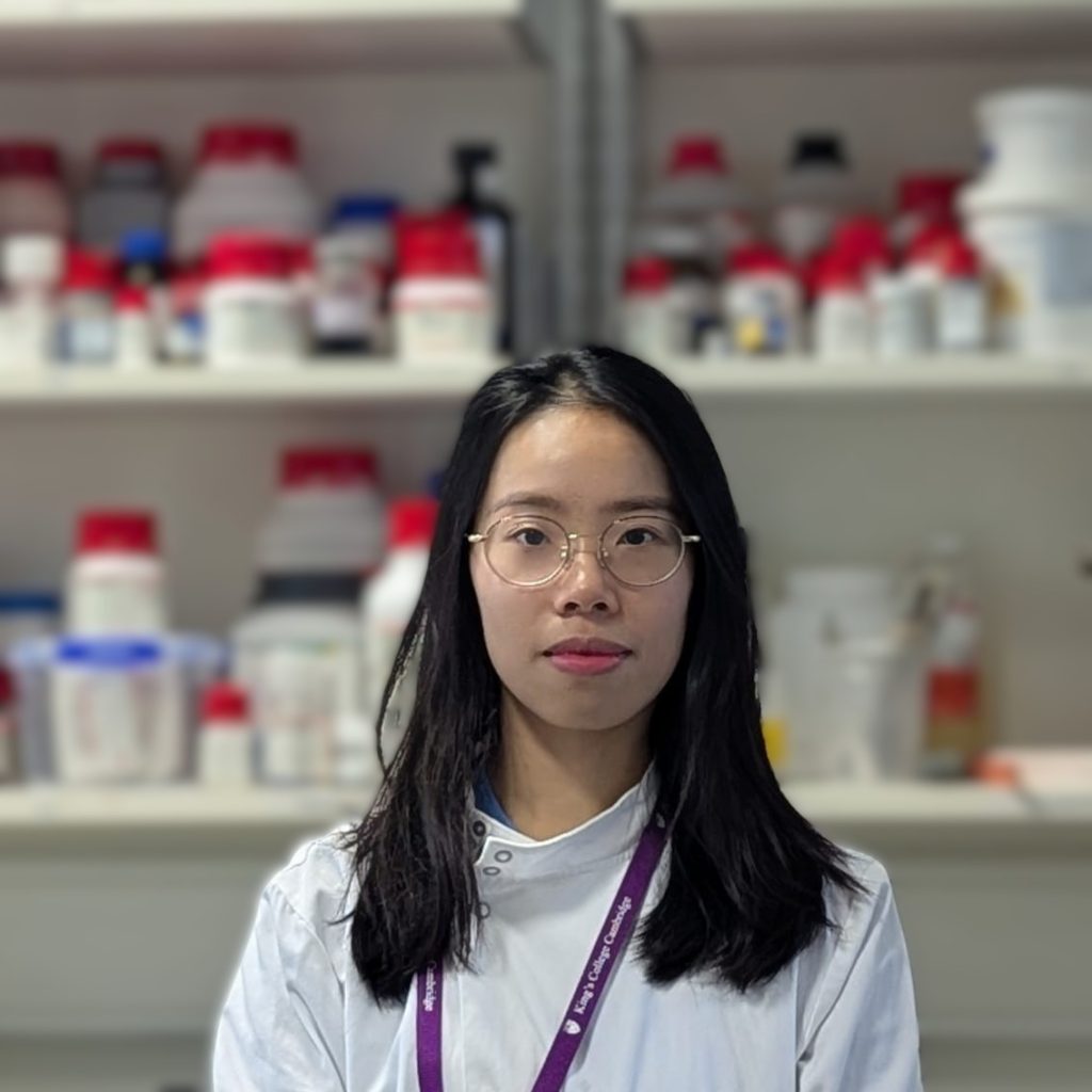 Portrait of a woman in a lab coat. A lab forms the background.