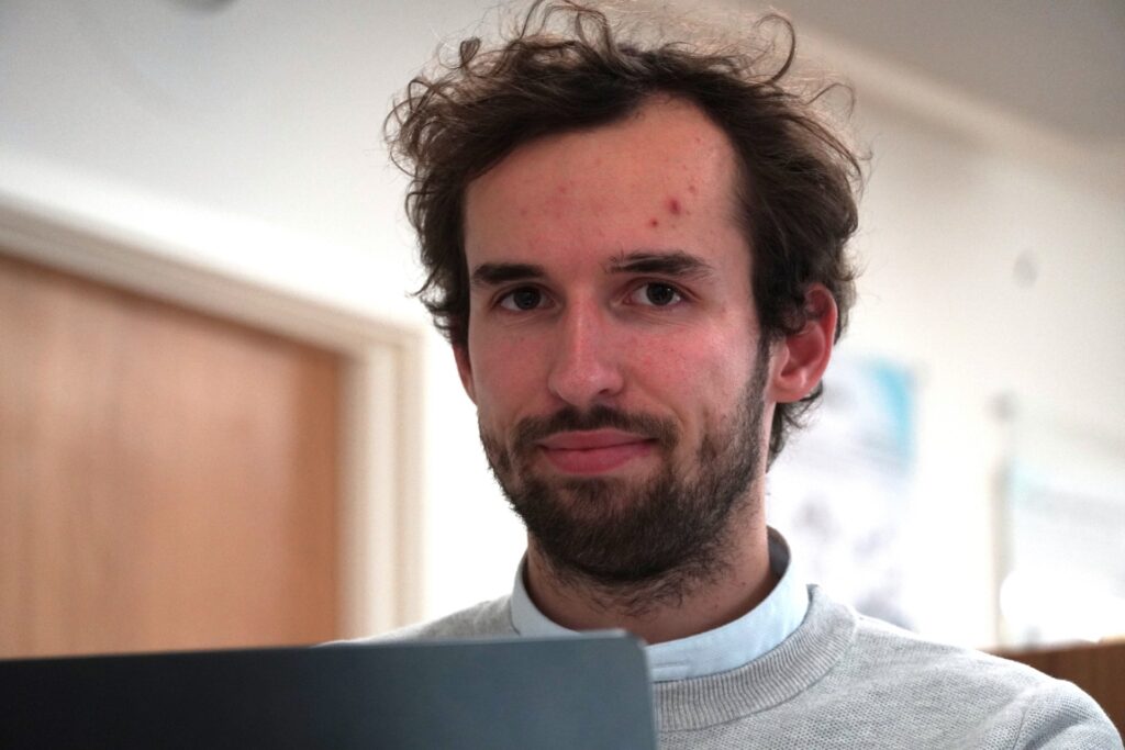 Man looking at camera in office setting.