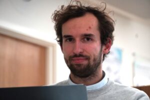 Man looking at camera in office setting.