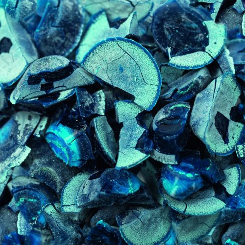 Blue and green shades of broken shards in close-up microscopy image of graphene.